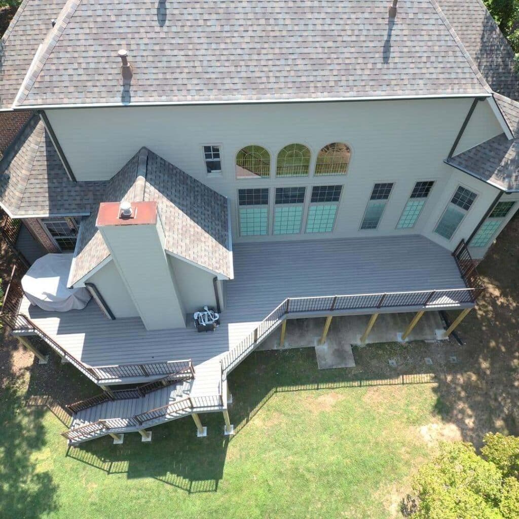 A home with a shingle roof and deck